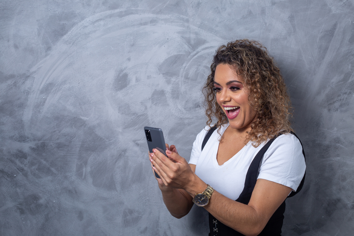 esteticista olhando no celular sorridente 