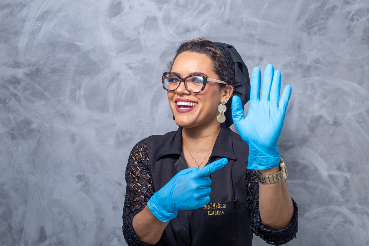 esteticista  de óculos sentada de touca e luvas