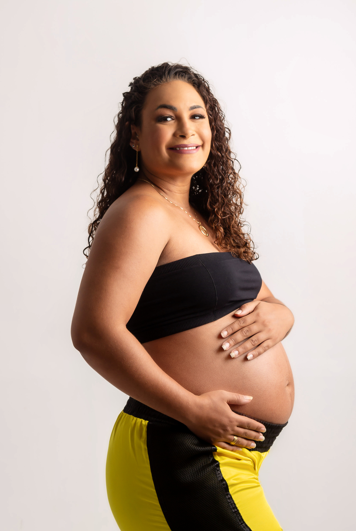 gestante com a mão da barriga e outra na cintura