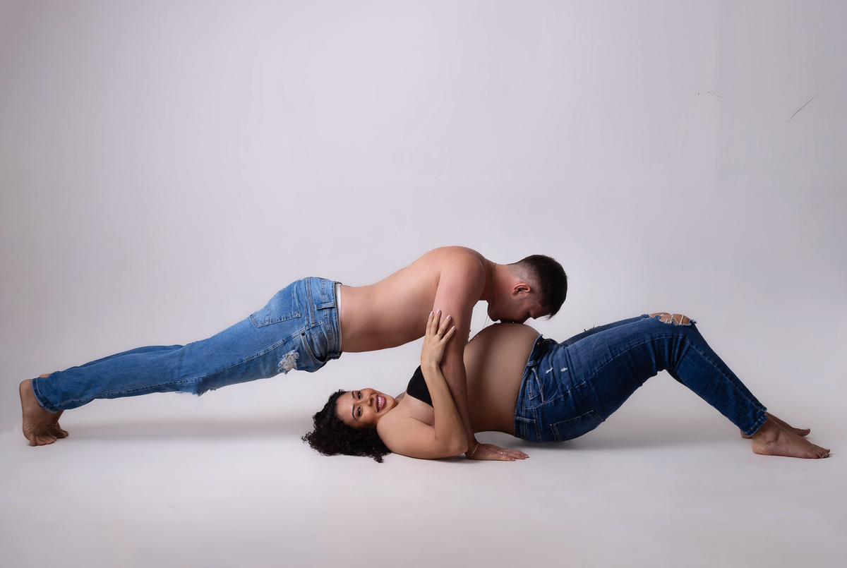 papai beijando a barriga da gestante deitada 