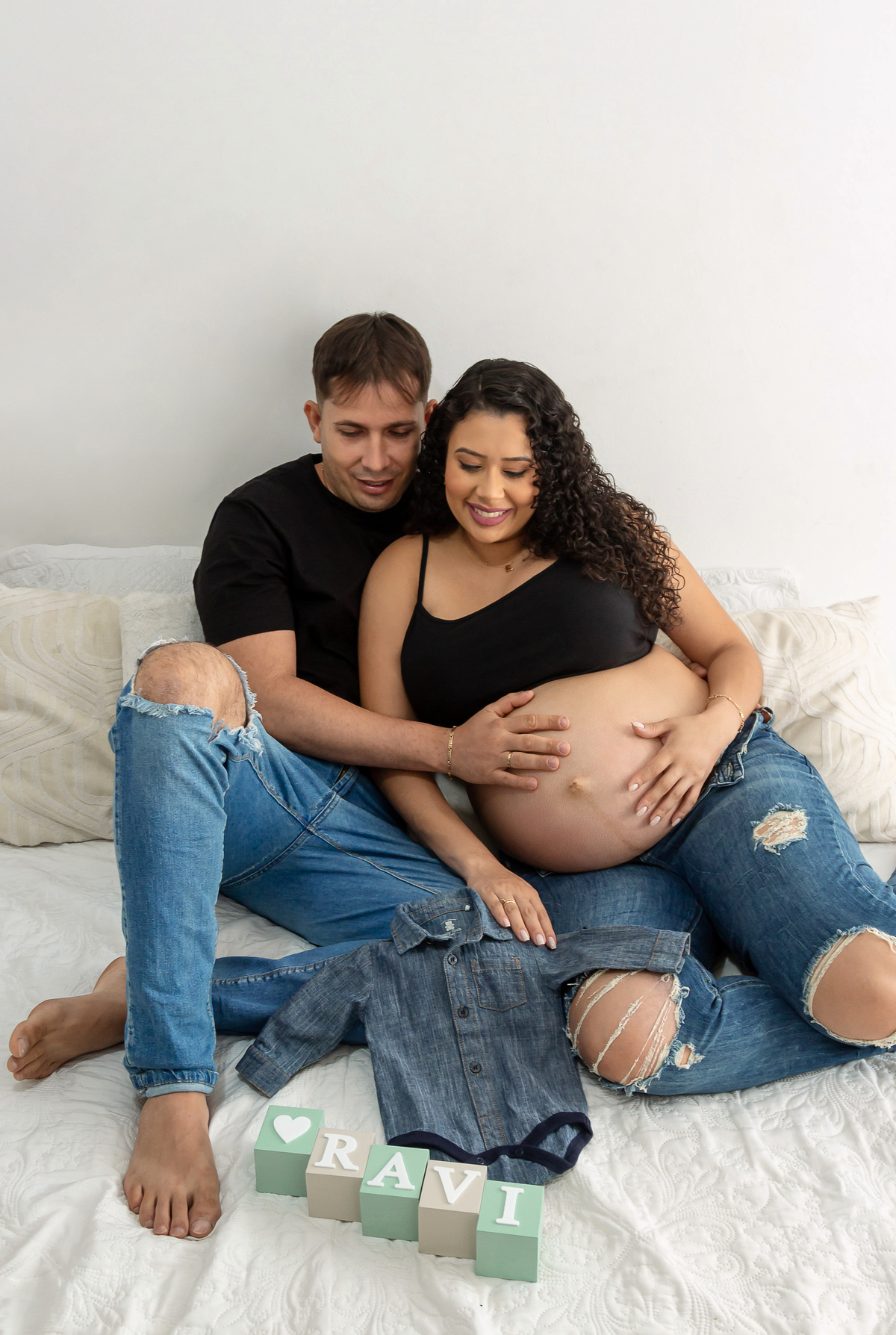 papai e mamãe olhando a roupinha do bebê