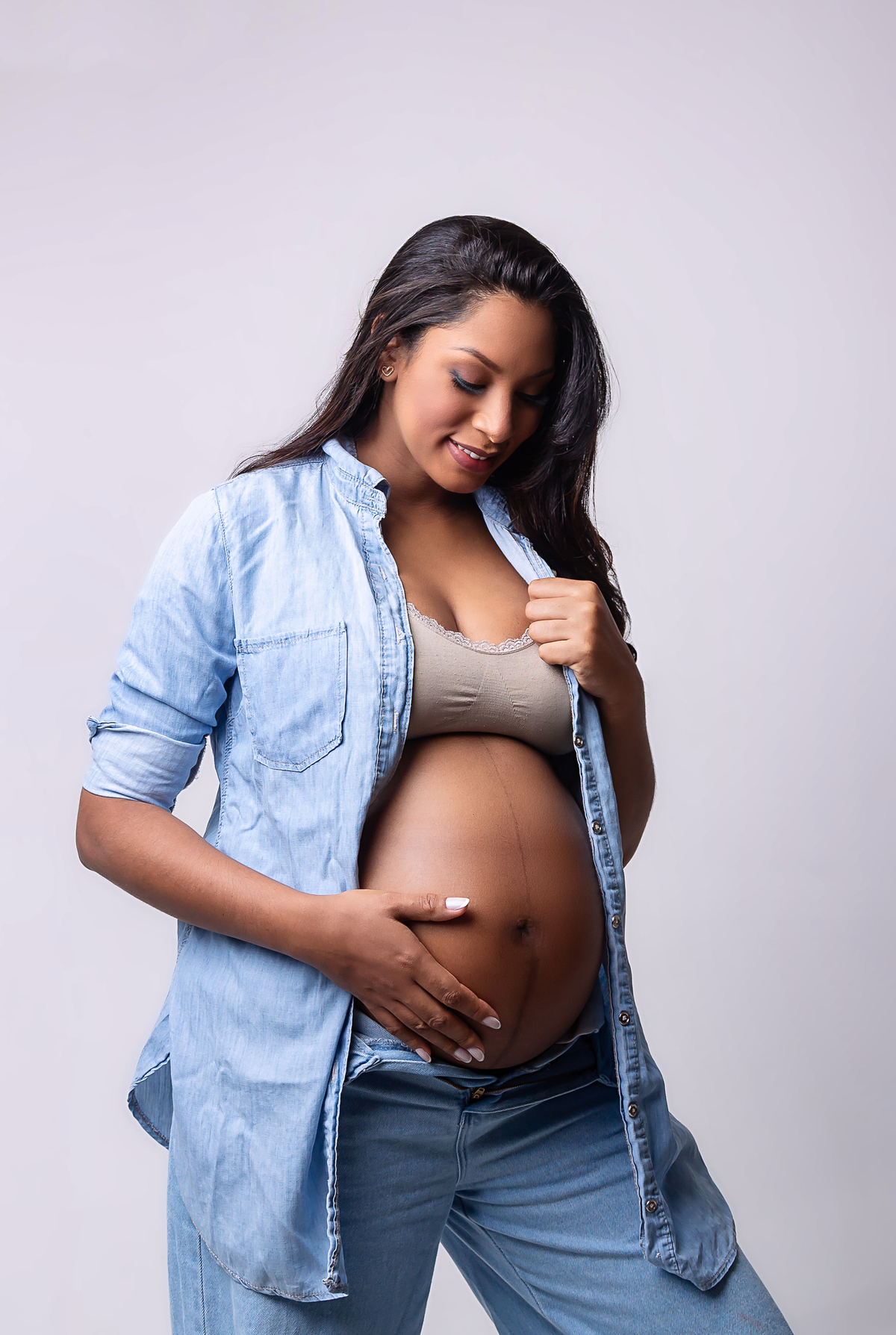 gestante olhando e tocando na barriga 
