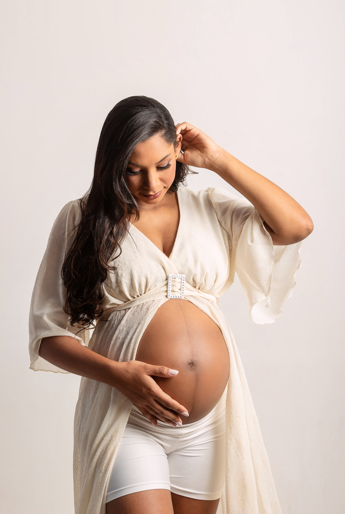 gestante com mão na cintura e outra no cabelo