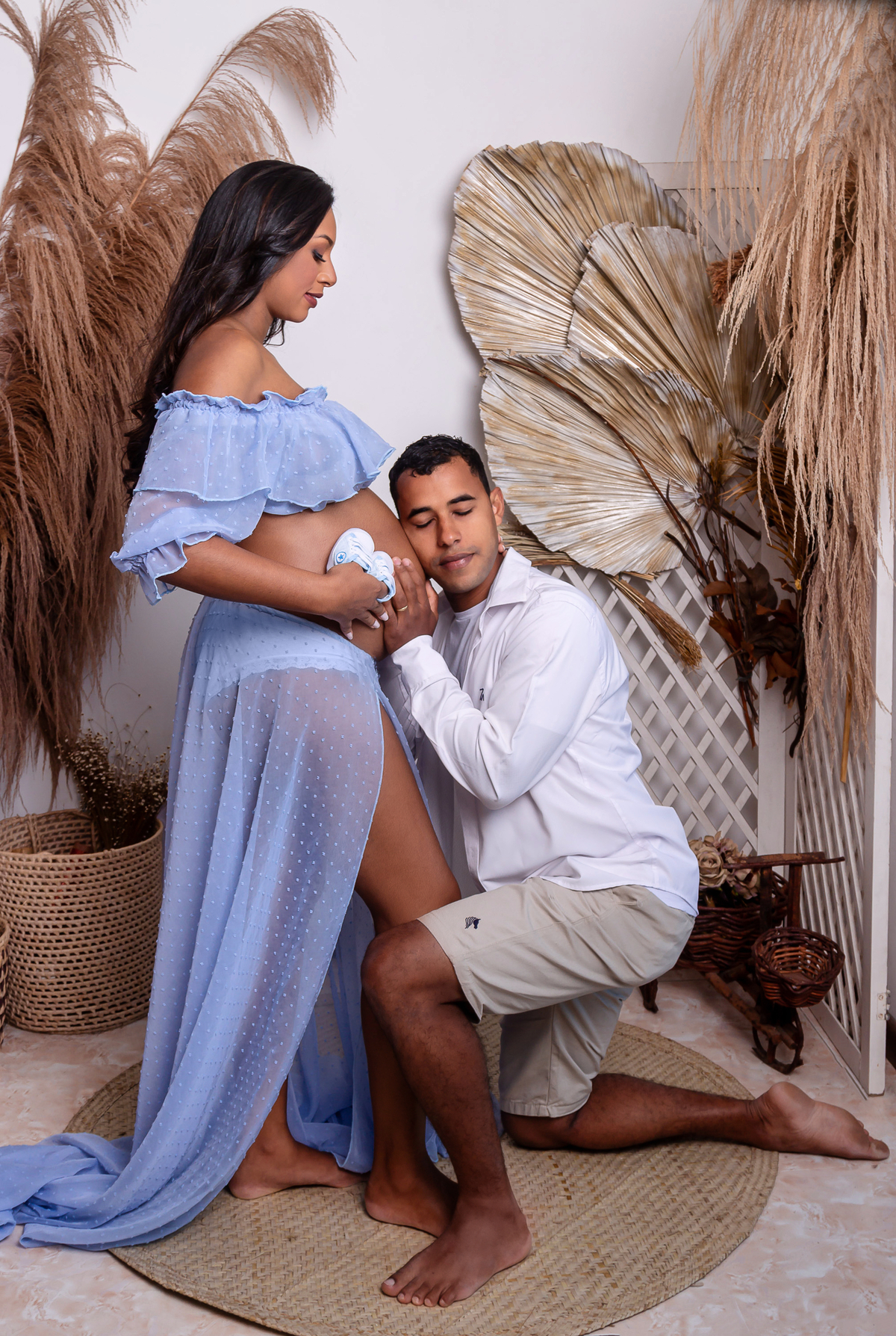 papai encostado da barriga da gestante com sapatinho