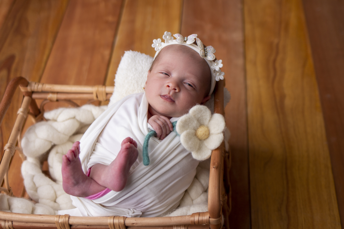 wrap newborn branco e props caixa segurando flor