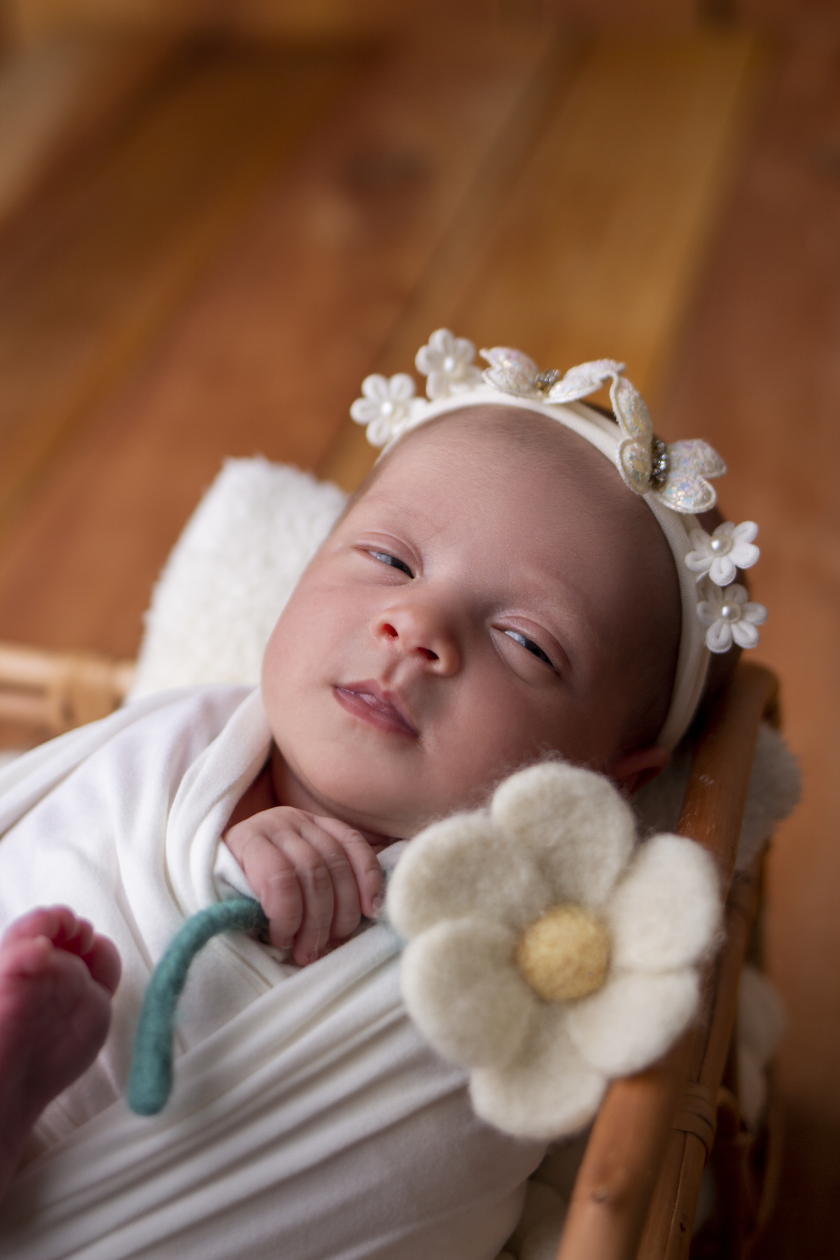 wrap newborn branco e props caixa segurando flor