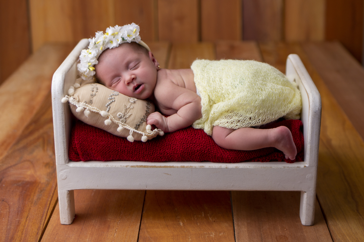 newborn de bruços na props cama 