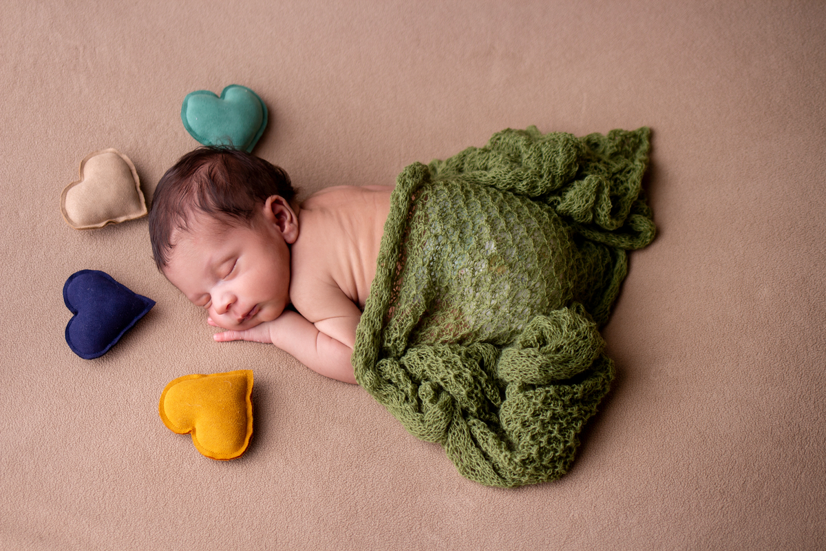 newborn de bruços com corações