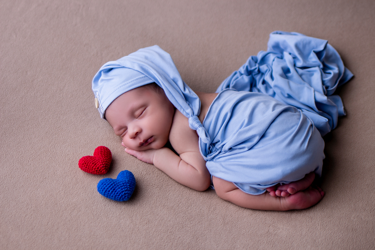newborn de bruços com corações
