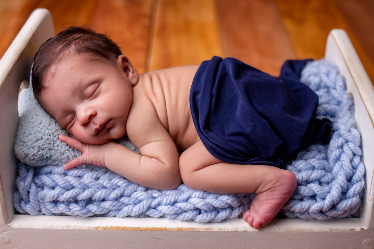 newborn de bruços na props cama