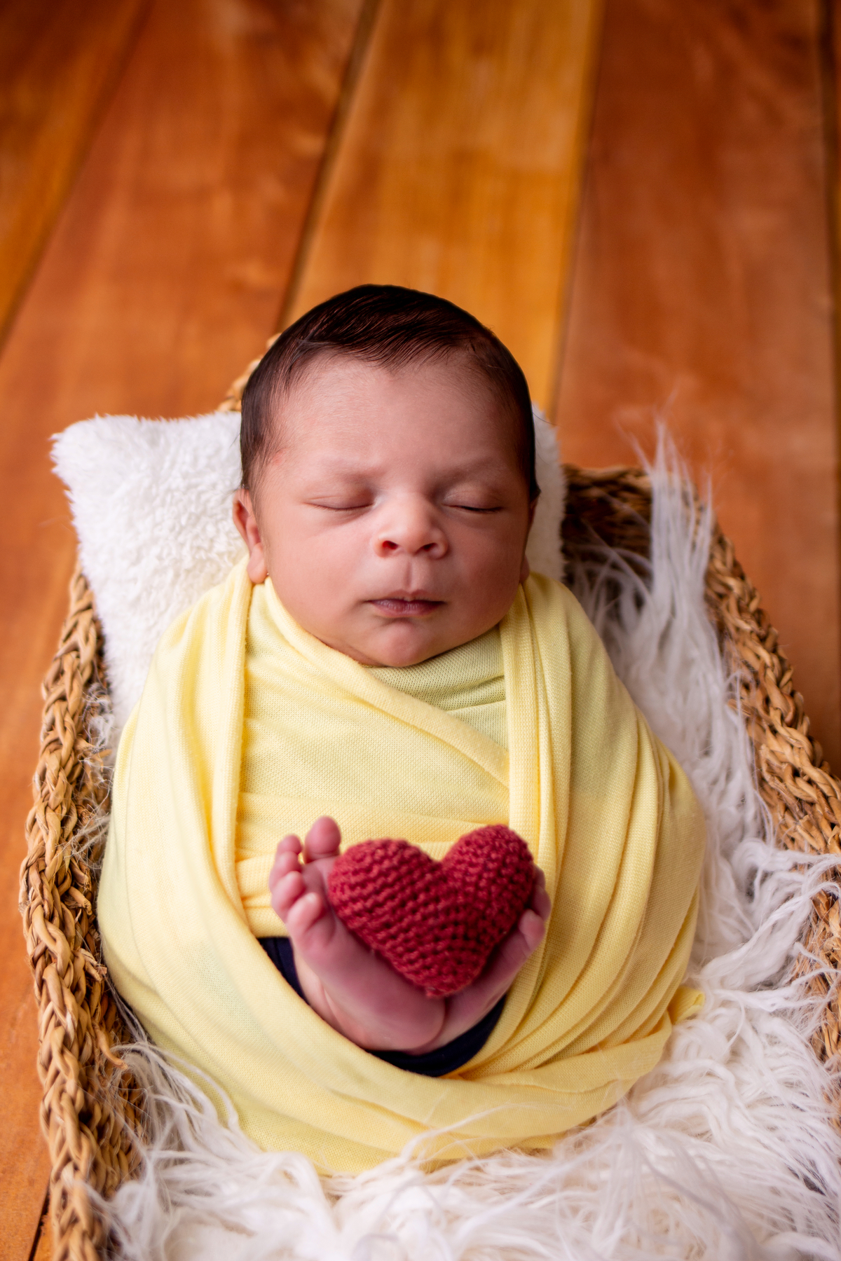 wrap newborn amarelo e props cesta segurando coração
