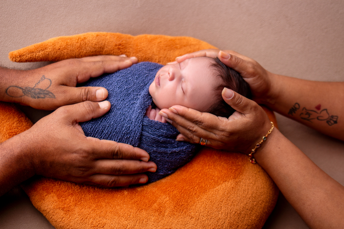 wrap newborn azul com as mãos de papai e mamãe