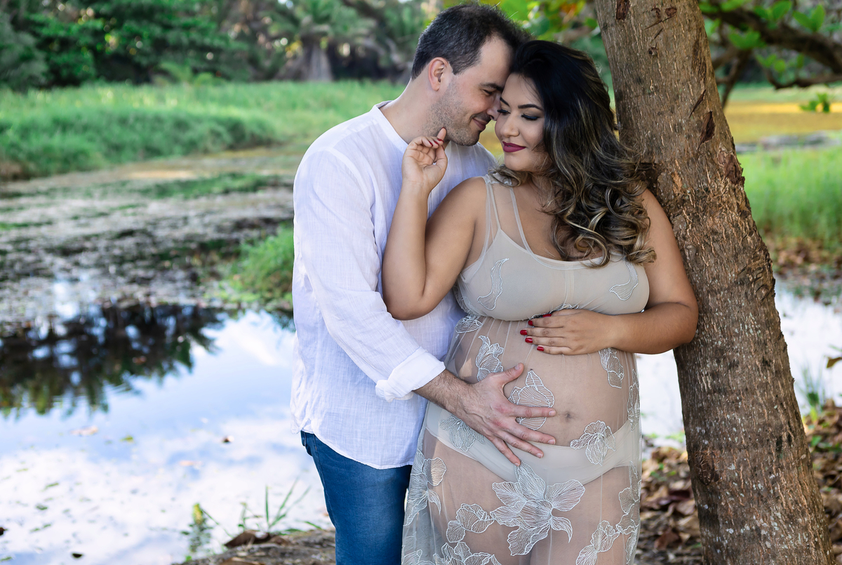 gestante encostada na árvore com seu marido