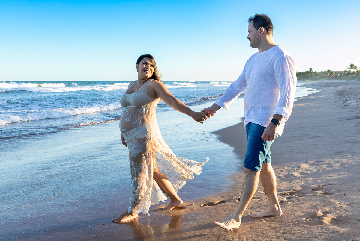 papai e mamãe caminhando na beira do mar