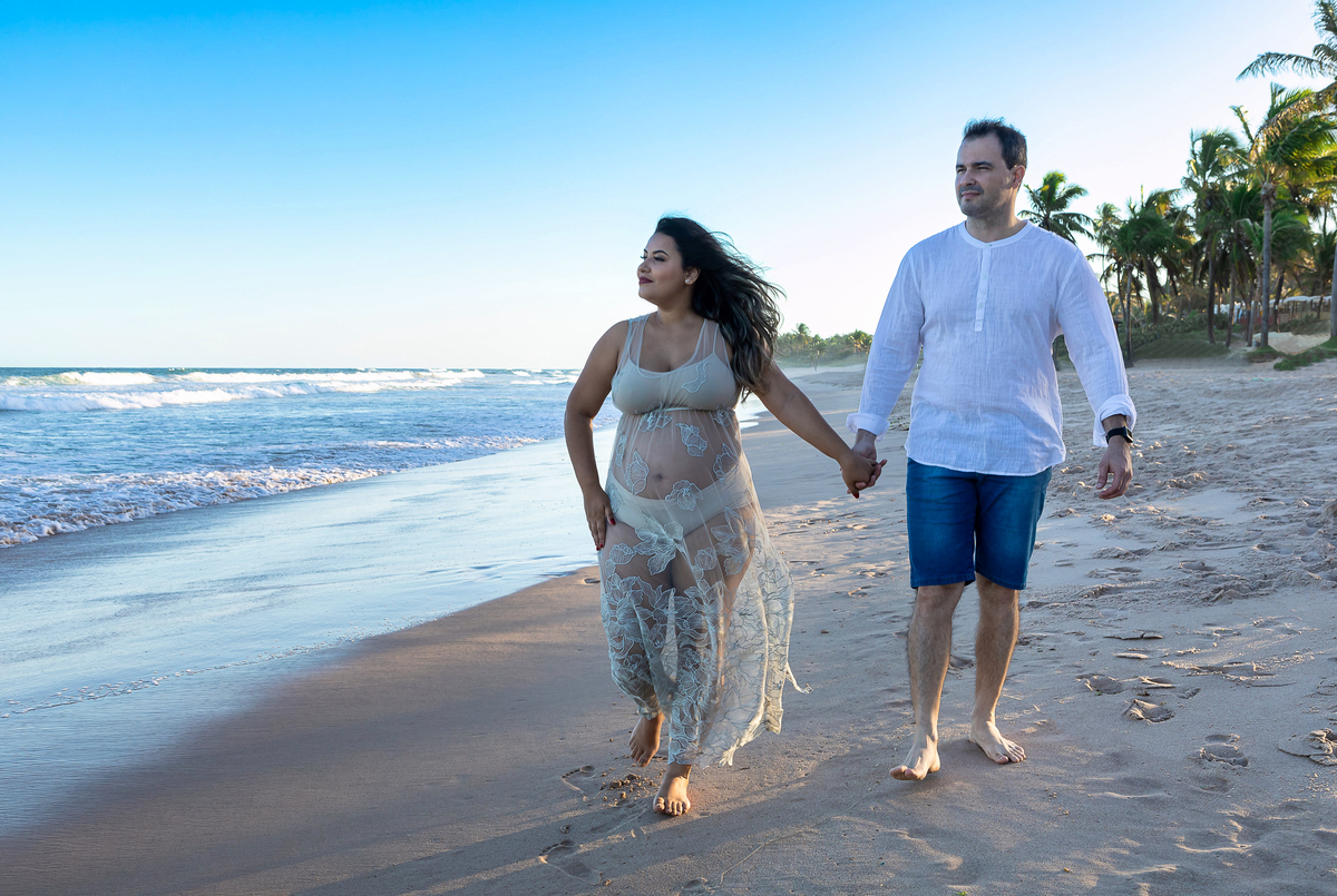 papai e mamãe caminhando na beira do mar