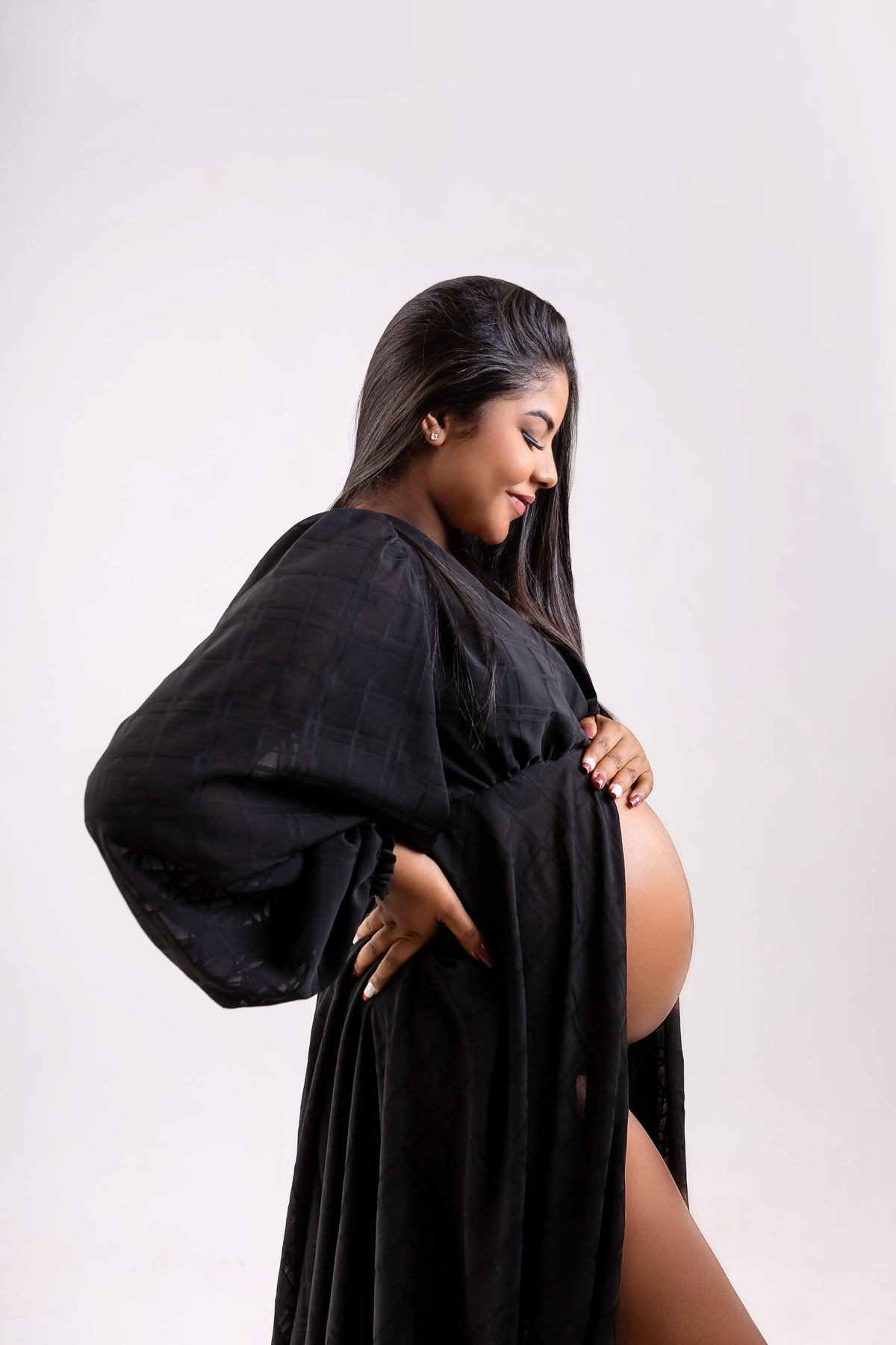 gestante olhando e tocando na barriga com na cintura