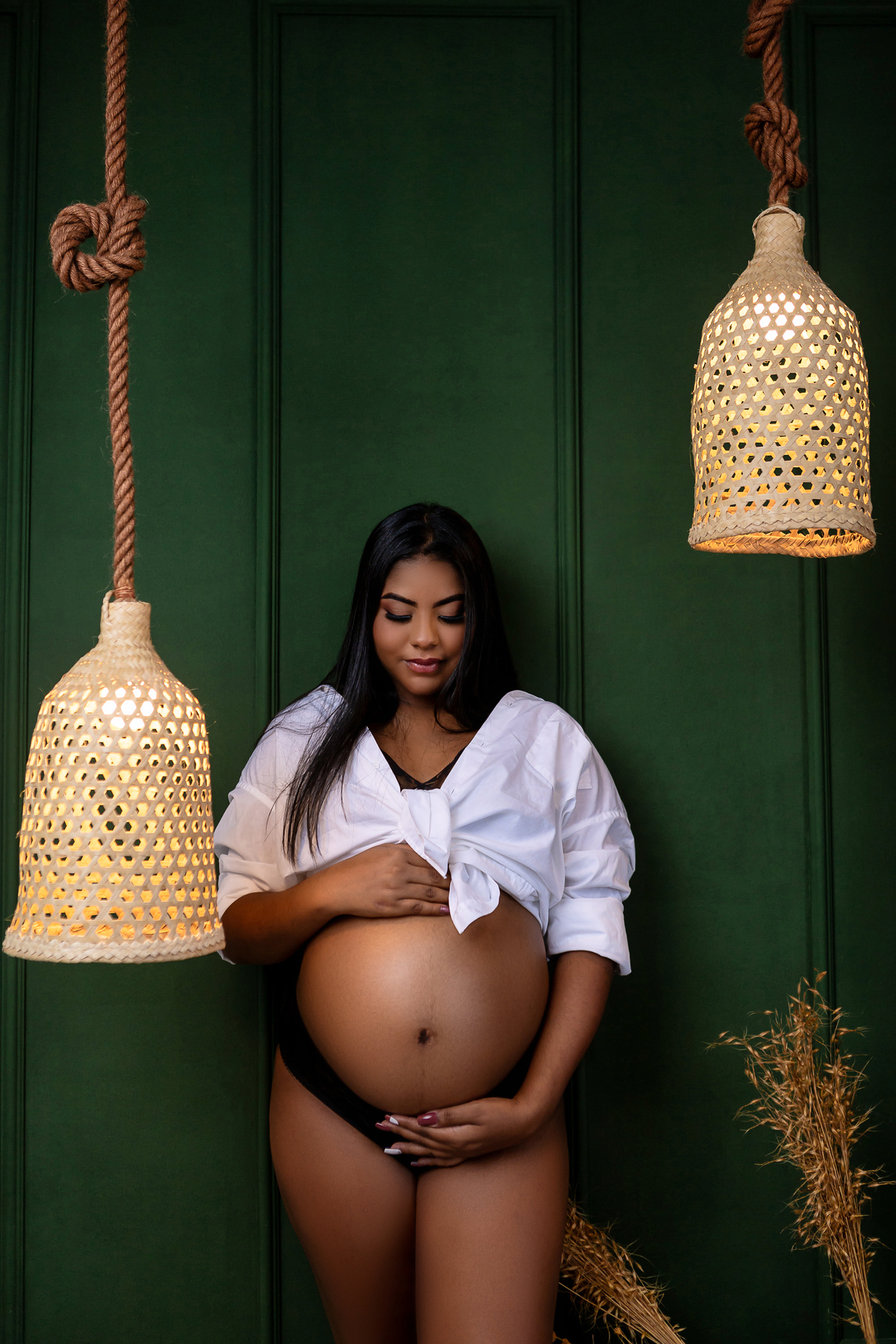 gestante encostada na parede abraçando a barriga