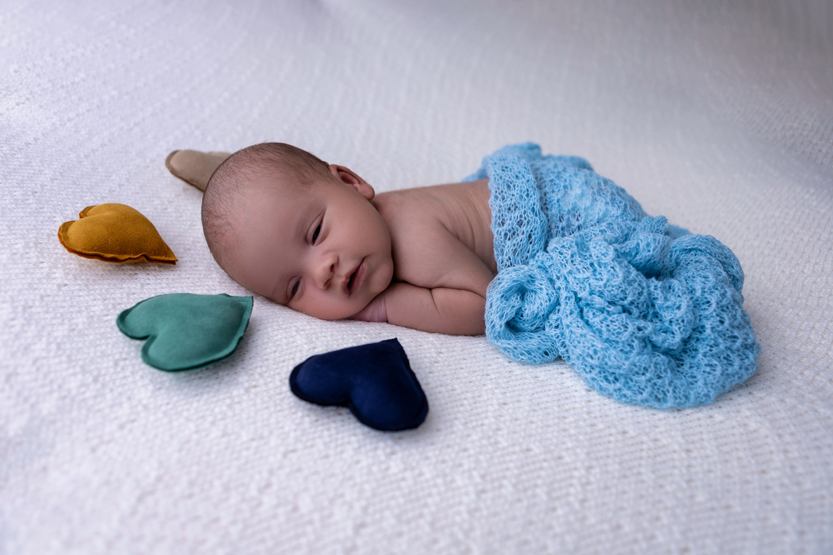 newborn de bruços com corações