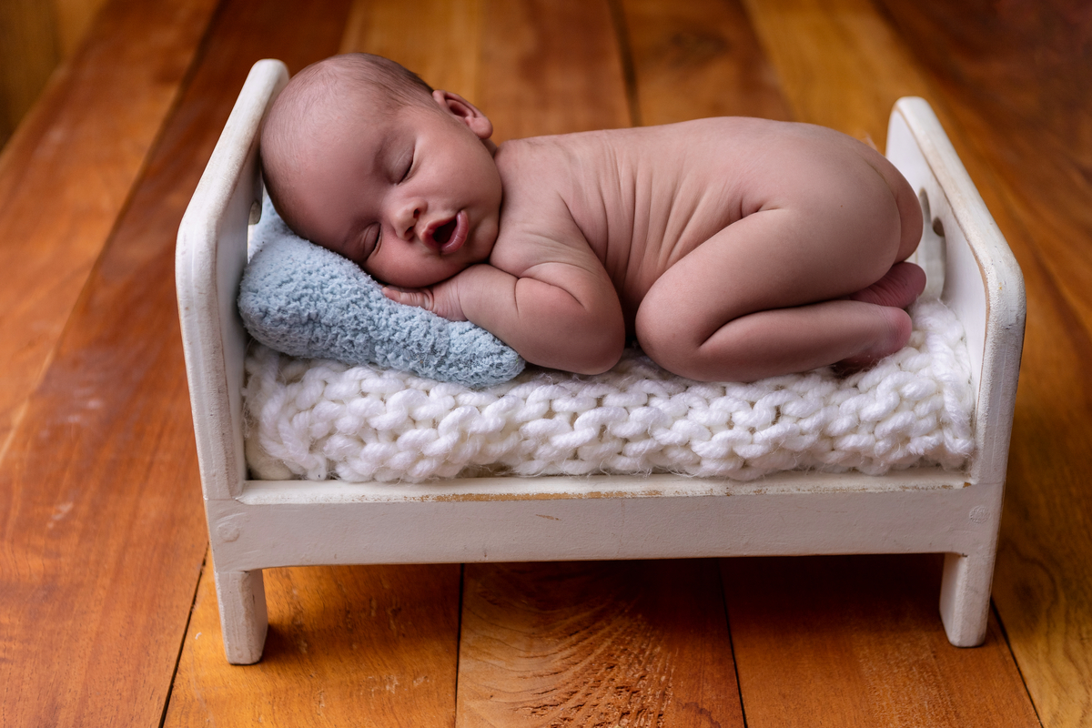 newborn de bruços na props cama