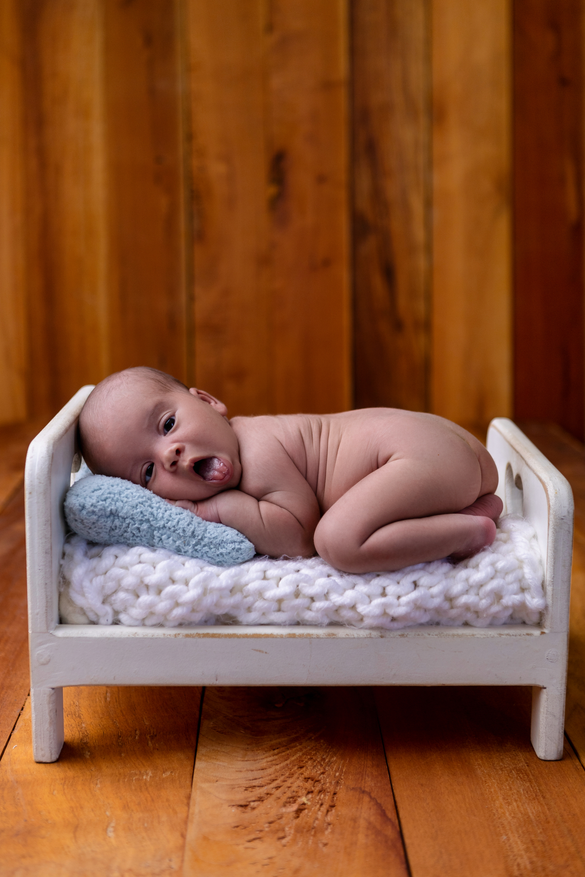 newborn de bruços na props cama