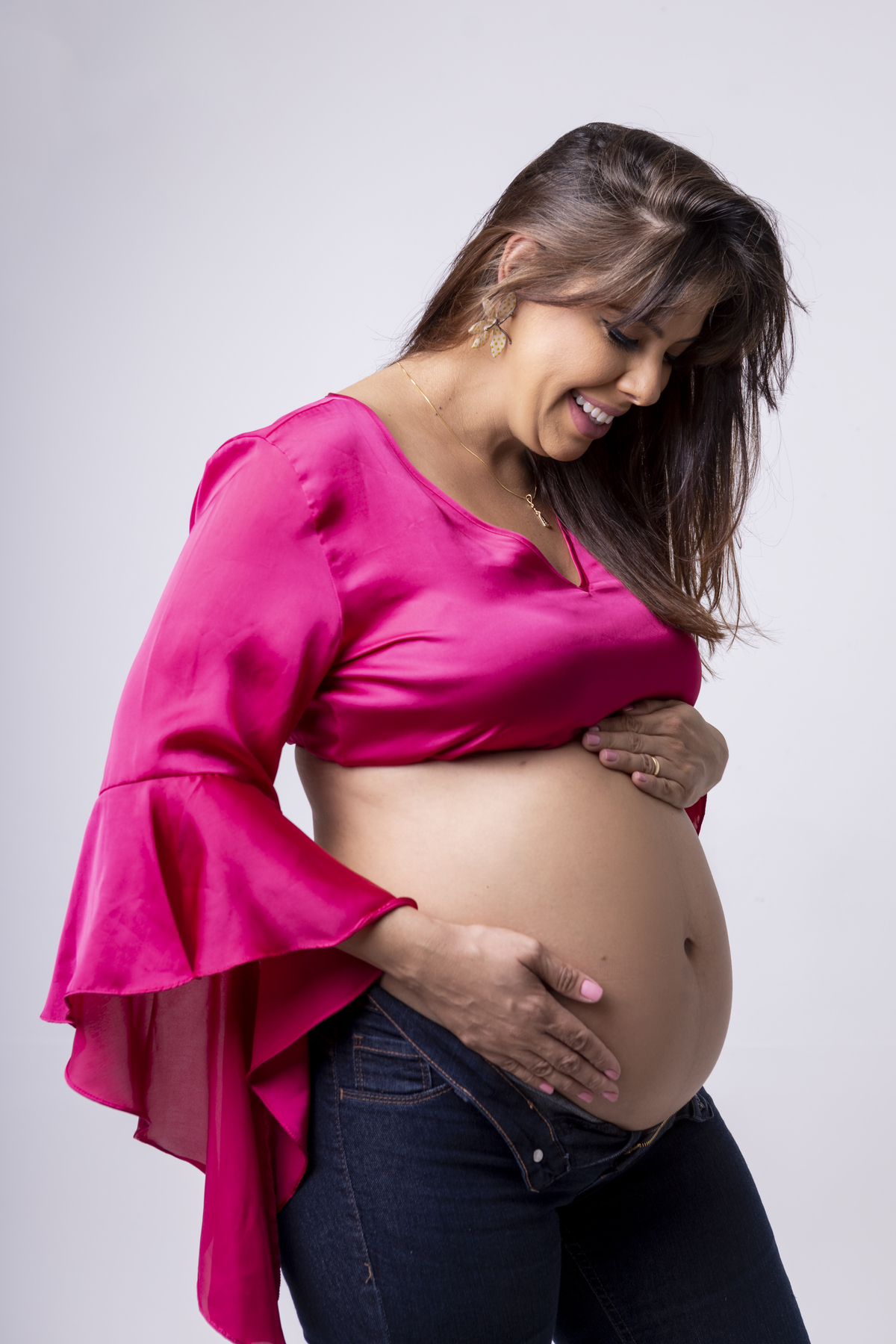 gestante segurando e olhando a barriga