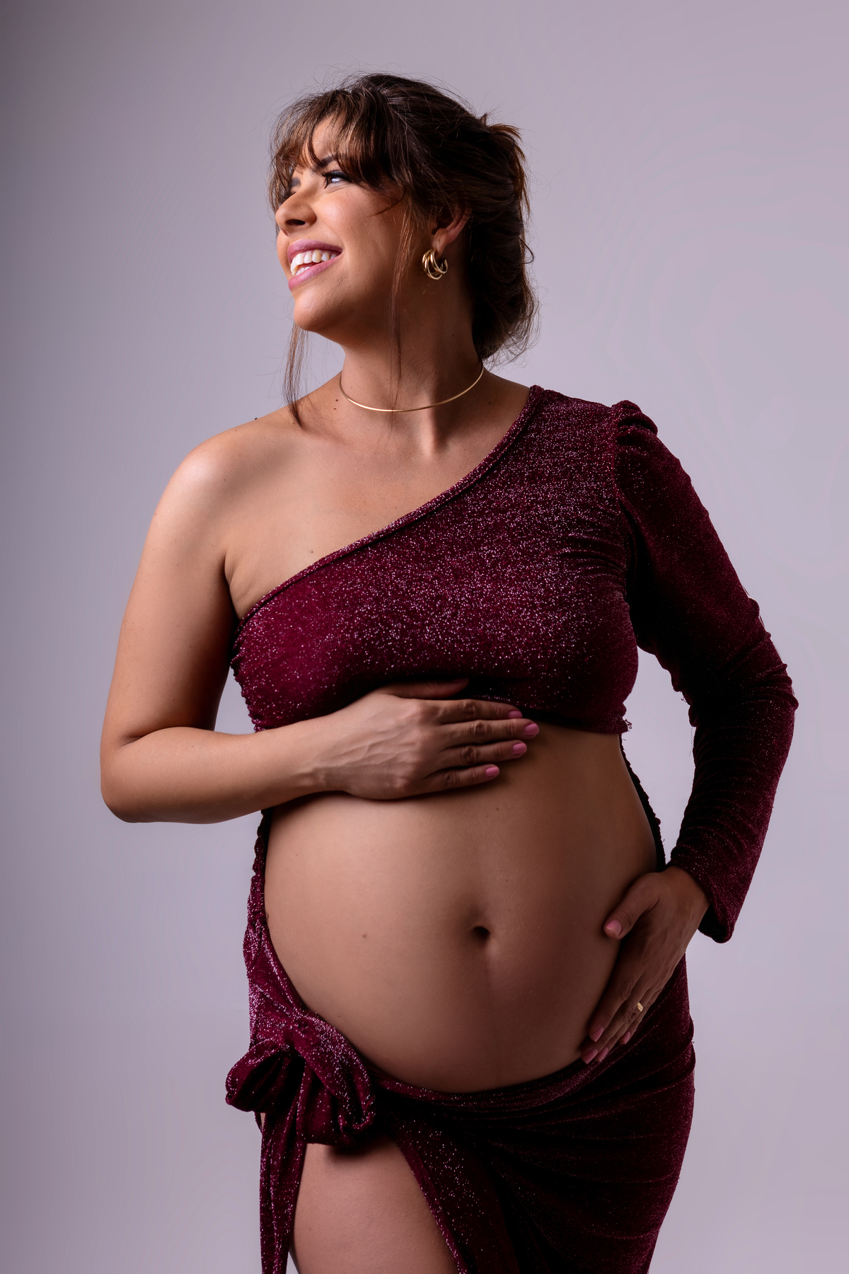 gestante abraçando a barriga olhando pro lado