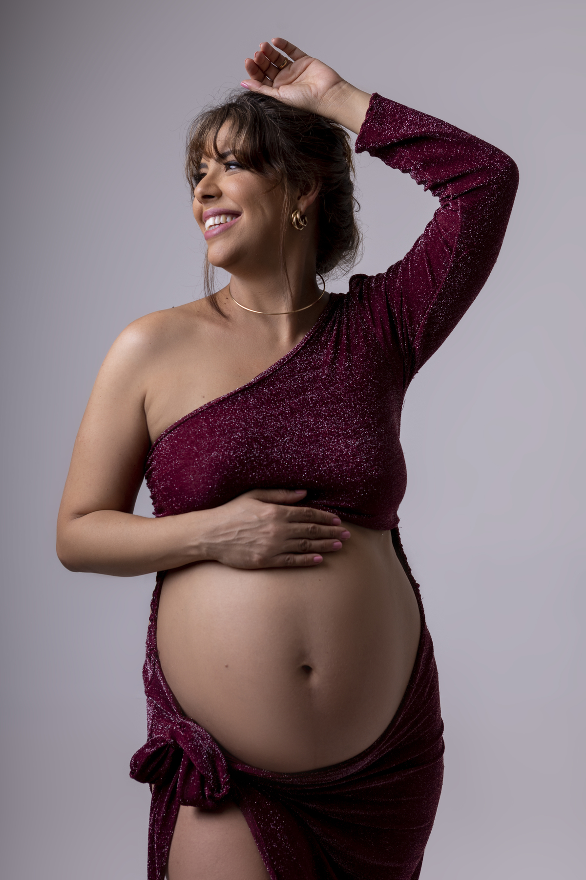 gestante com mão na barriga e outra no cabelo