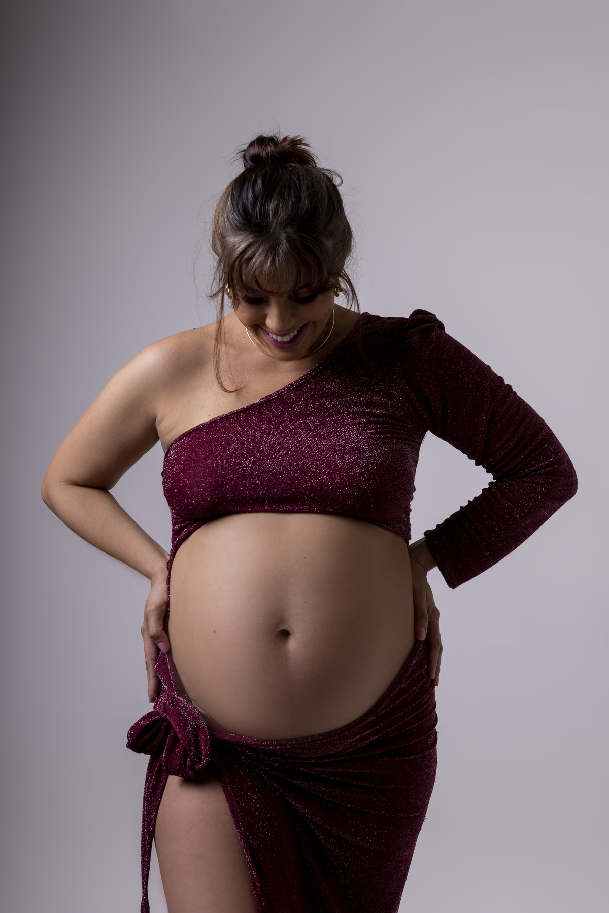 gestante com mãos na cintura e olhando pra barriga