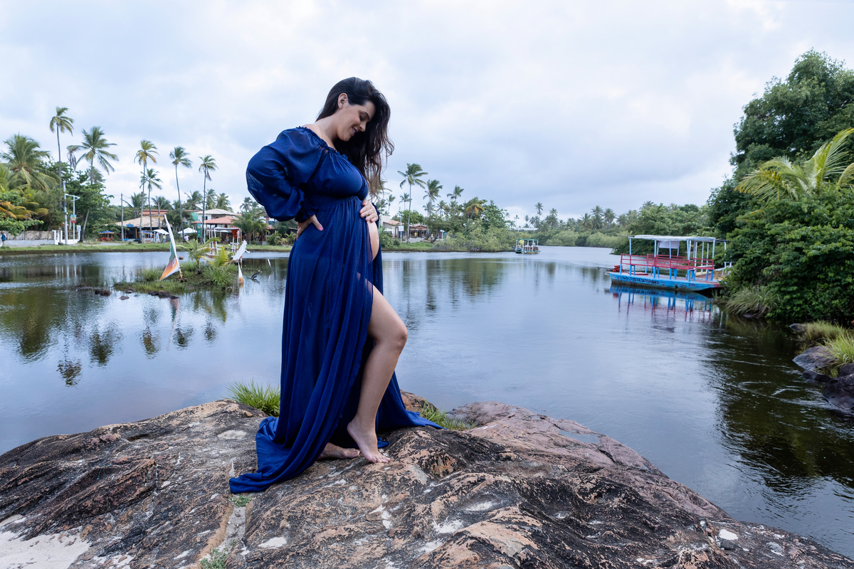 gestante com mão na cintura e outra na barriga do lago
