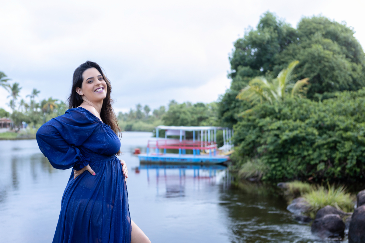 gestante com mão na cintura e outra na barriga do lago