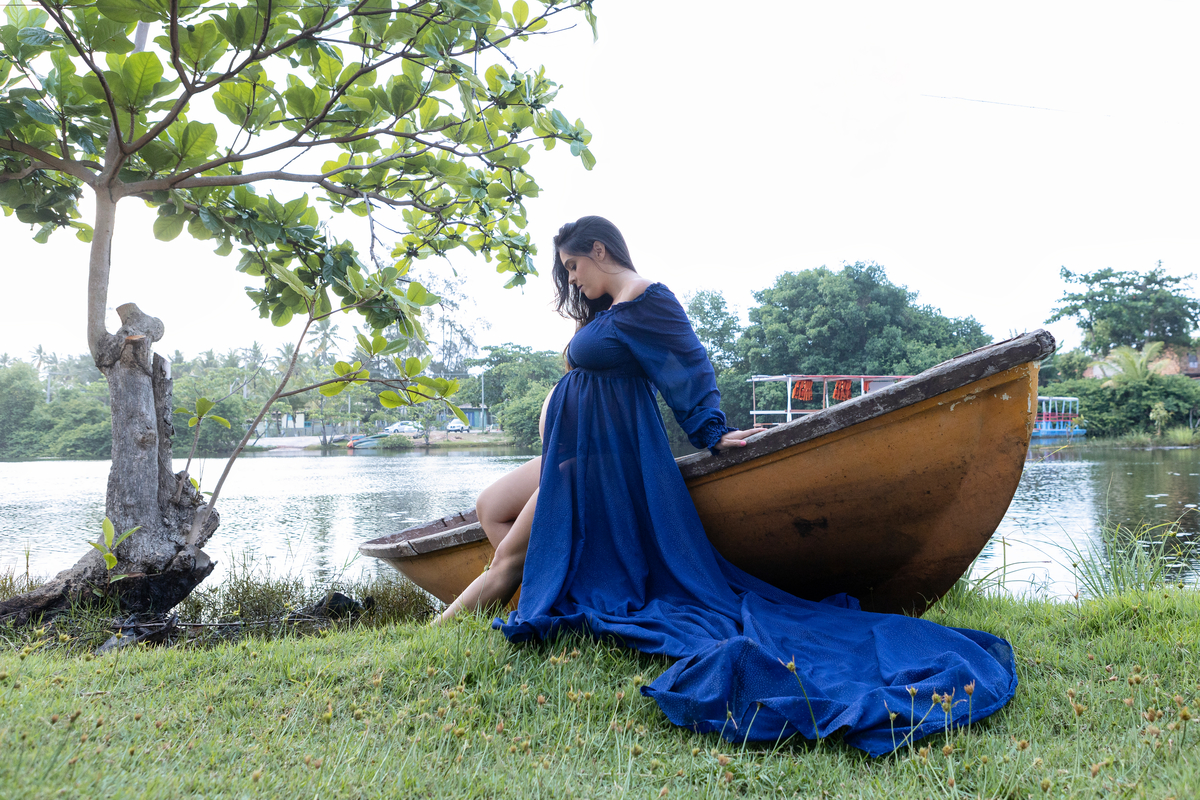 gestante sentada na canoa e olhando na barriga do lago