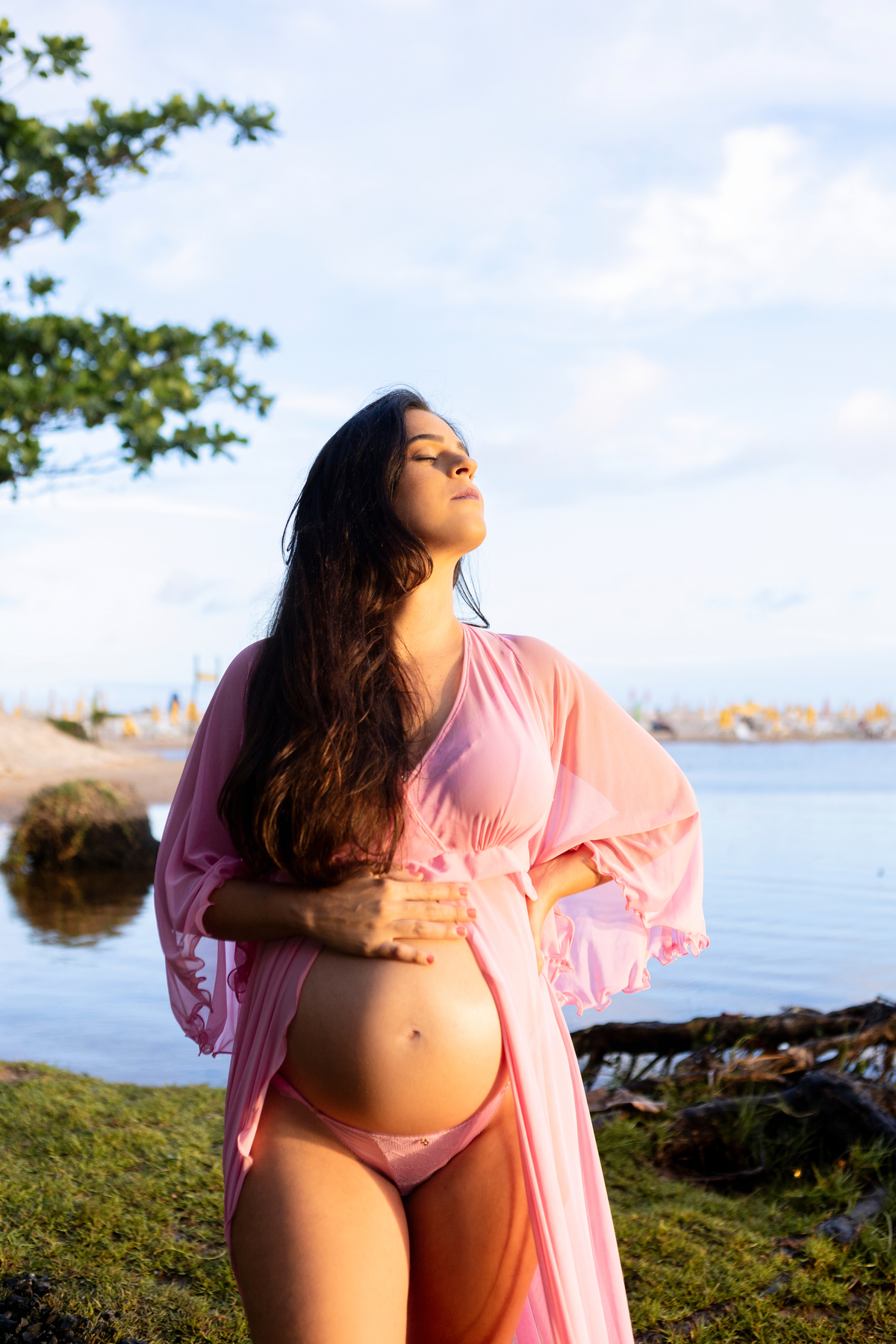 gestante com mão na cintura e outra na barriga do lago