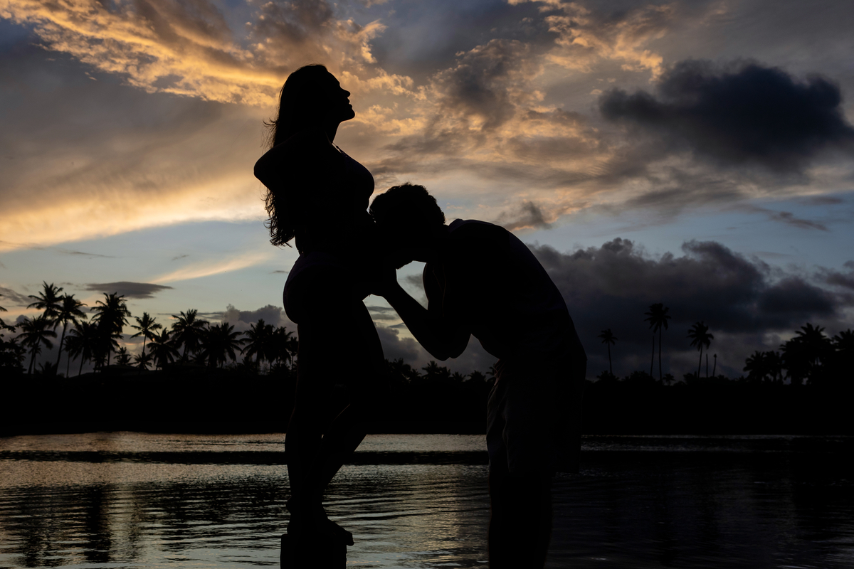 silhueta papai beijando a barriga da gestante no lago