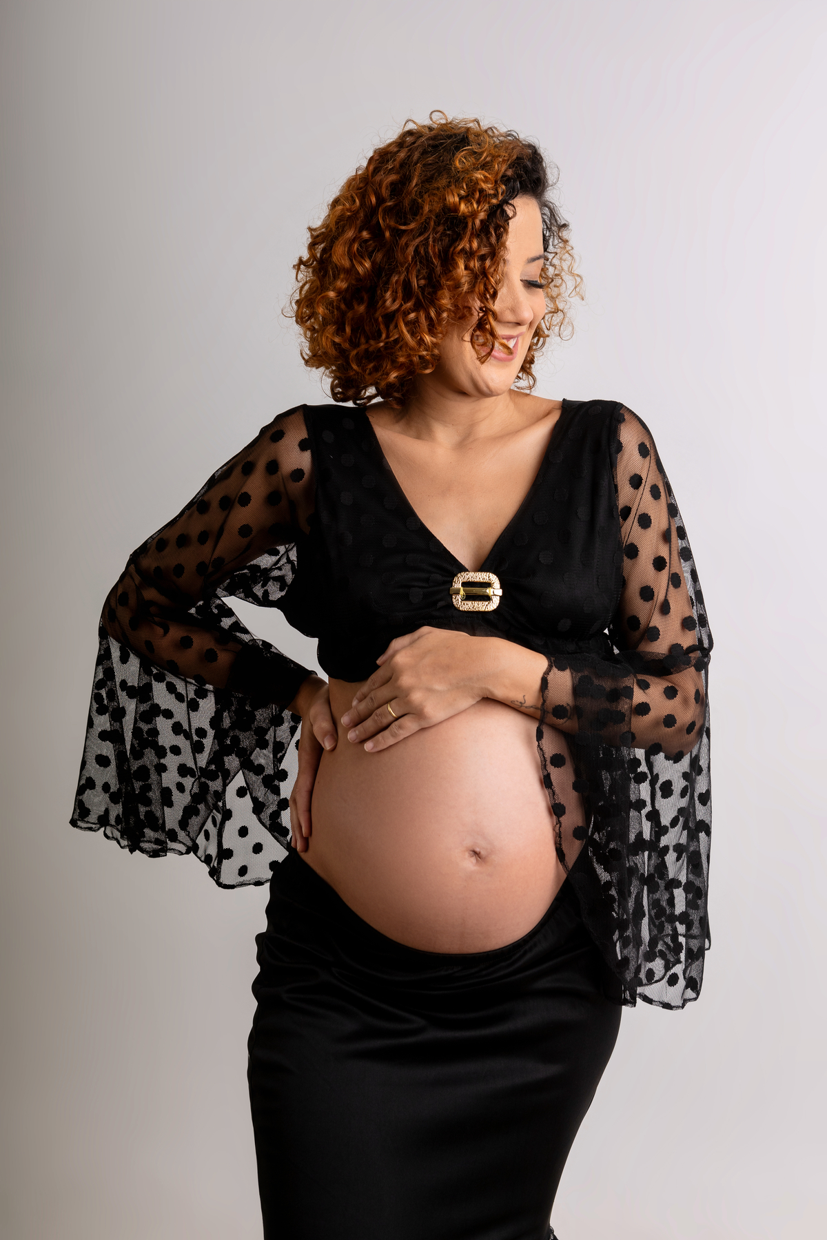 gestante com mão na cintura e outra na barriga