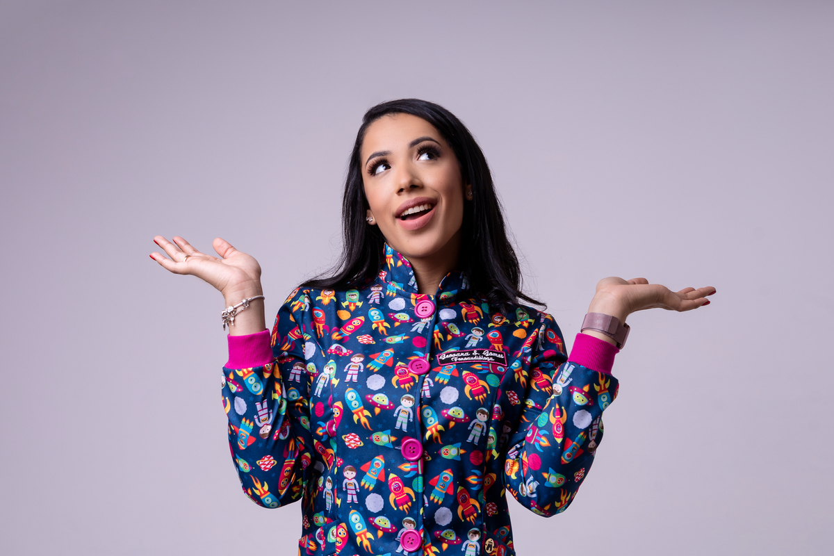 fonoaudióloga com jaleco com expressão de dúvida