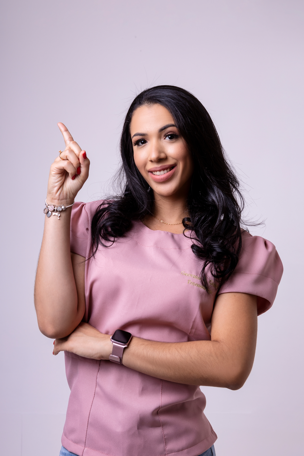 fonoaudióloga de braço cruzado apontando pra cima