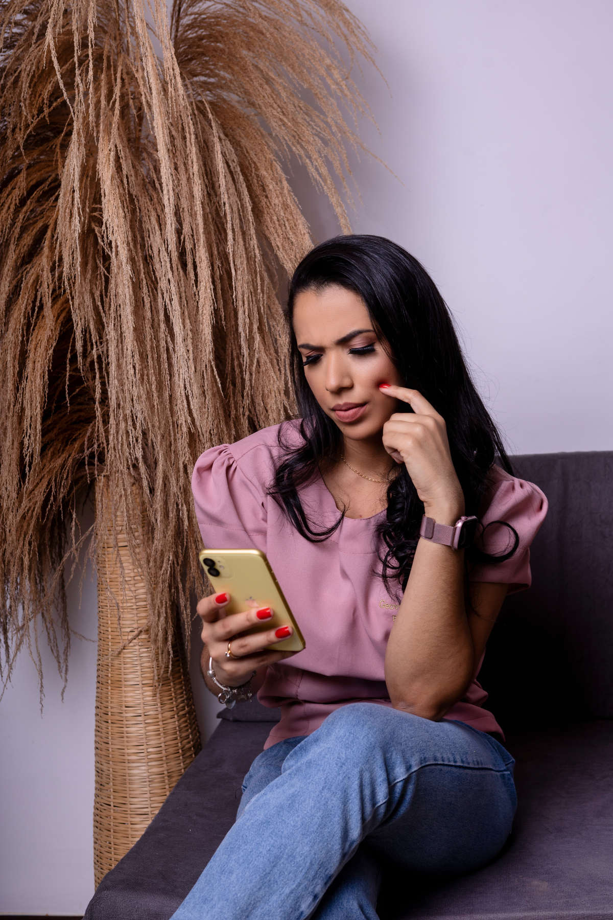 fonoaudióloga sentada olhando no celular expressão de dúvida