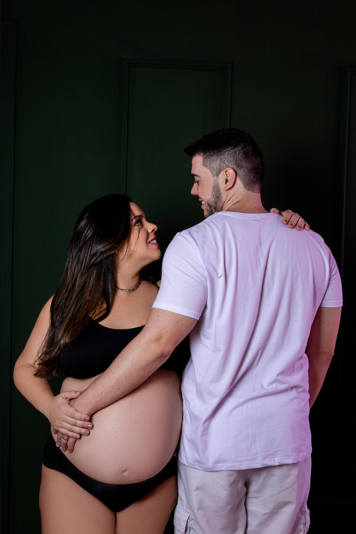 papai de costa tocando na barriga na mamãe