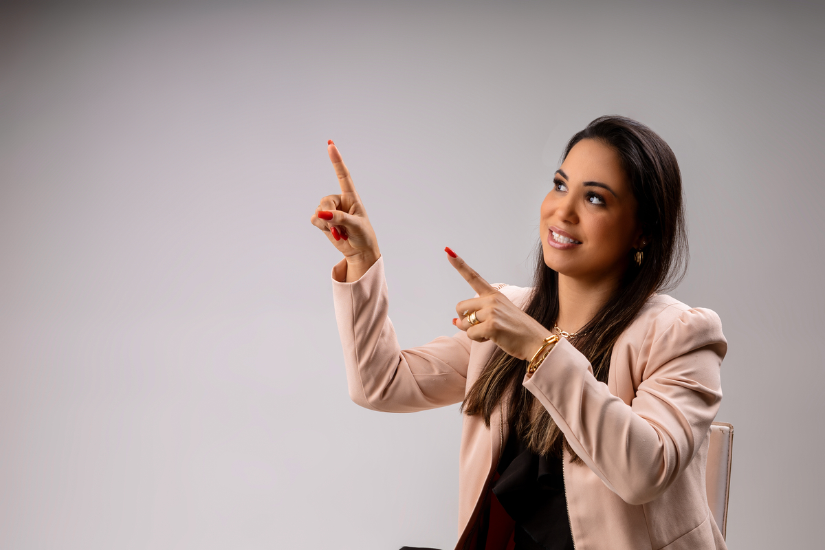 advogada sentada apontando pra cima