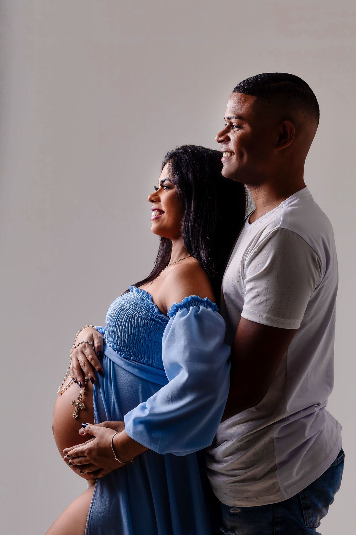 gestante e papai abraçando a barriga com terço