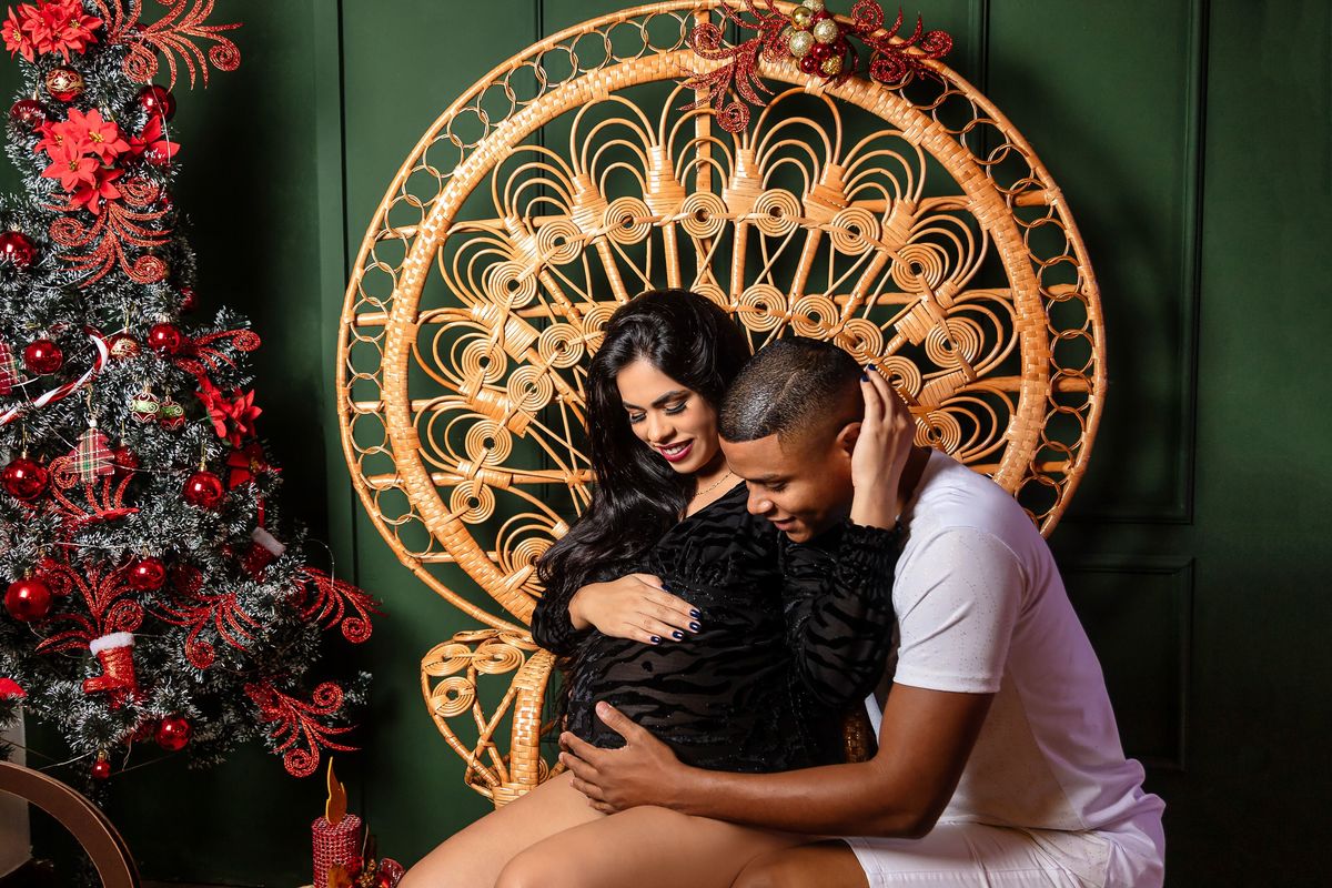 gestante sentada com papai ajoelhado olhando pra barriga