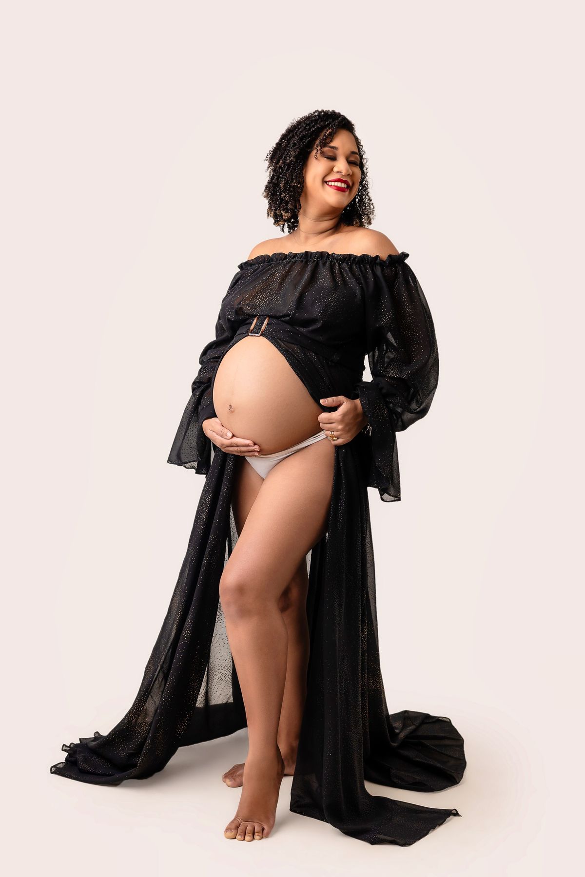 gestante segurando vestido e tocando na barriga