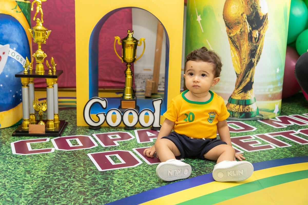 aniversariante sentado no chão com cenário  copa do mundo