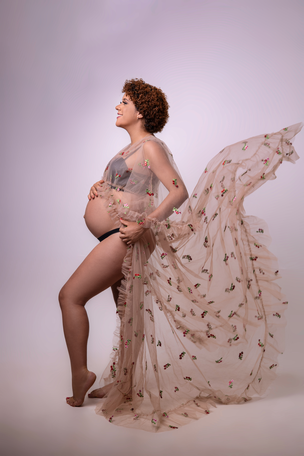 gestante com mão segurando o vestido e outro na barriga