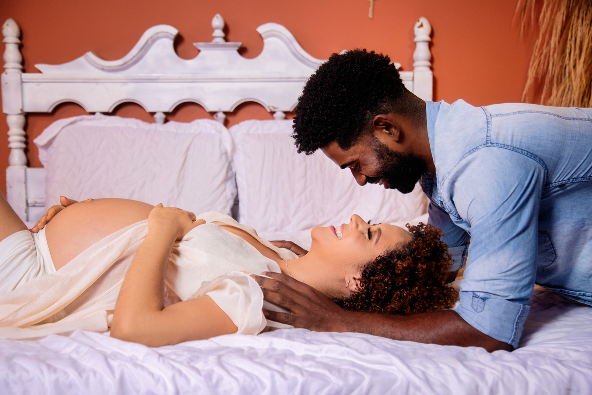 gestante deitada abraçando a barriga com papai