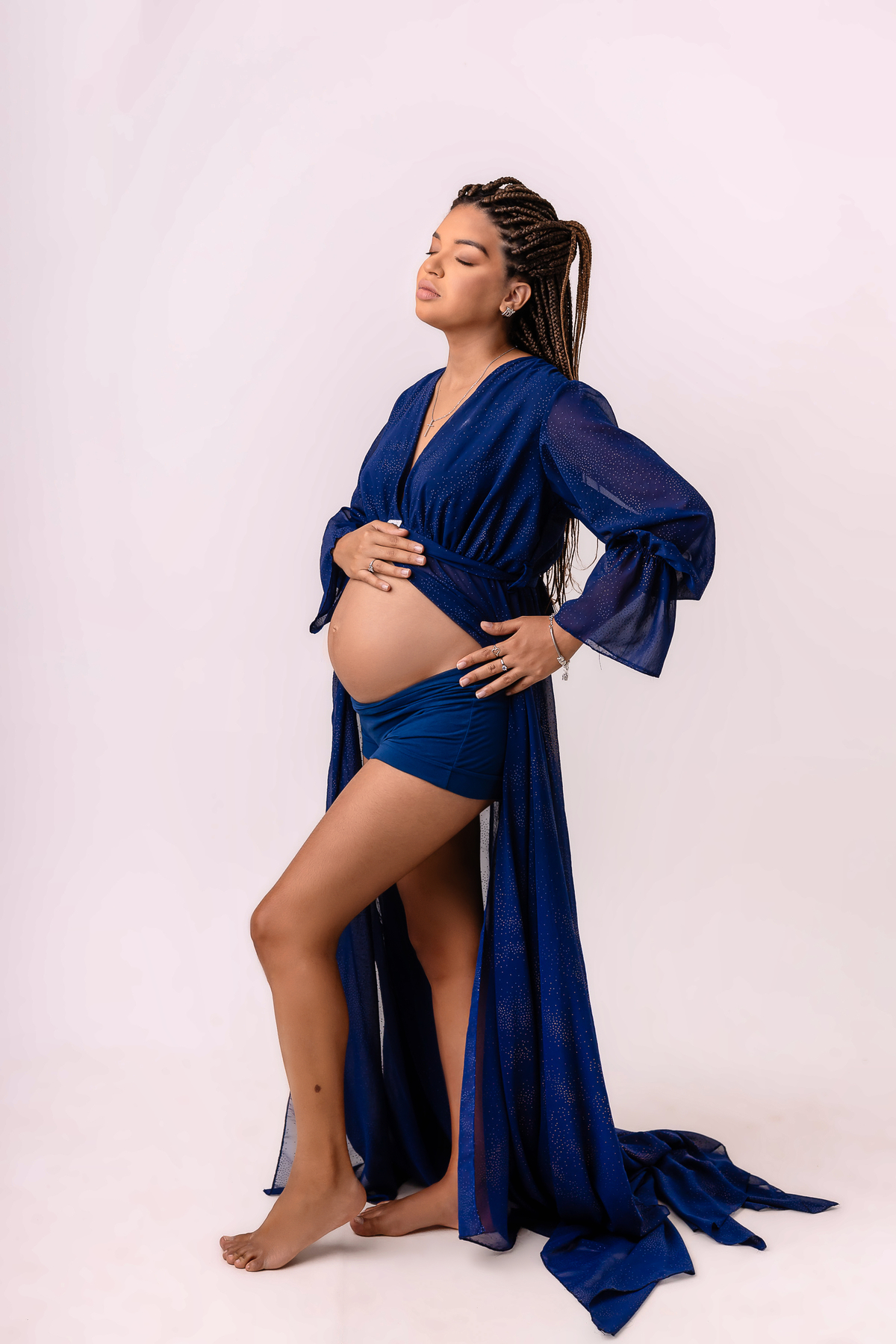 gestante tocando na barriga e mão na cintura