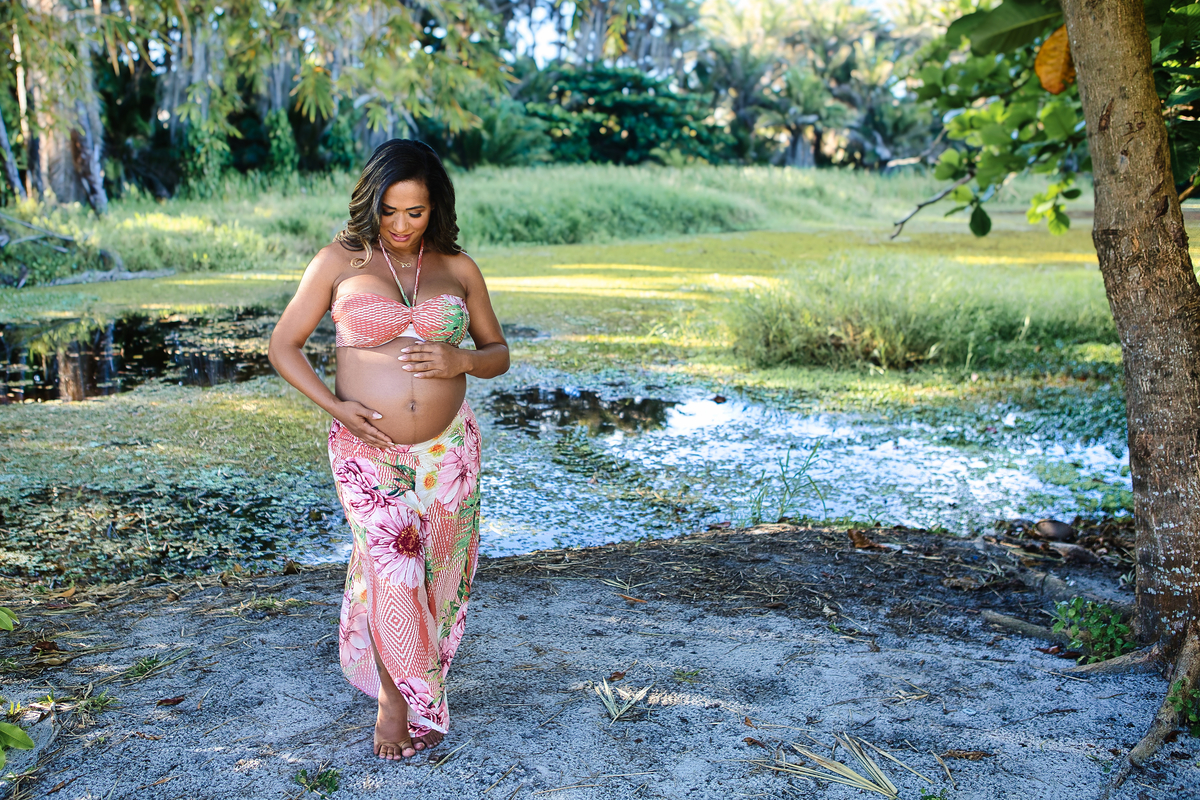 gestante tocando na barriga na beira do rio