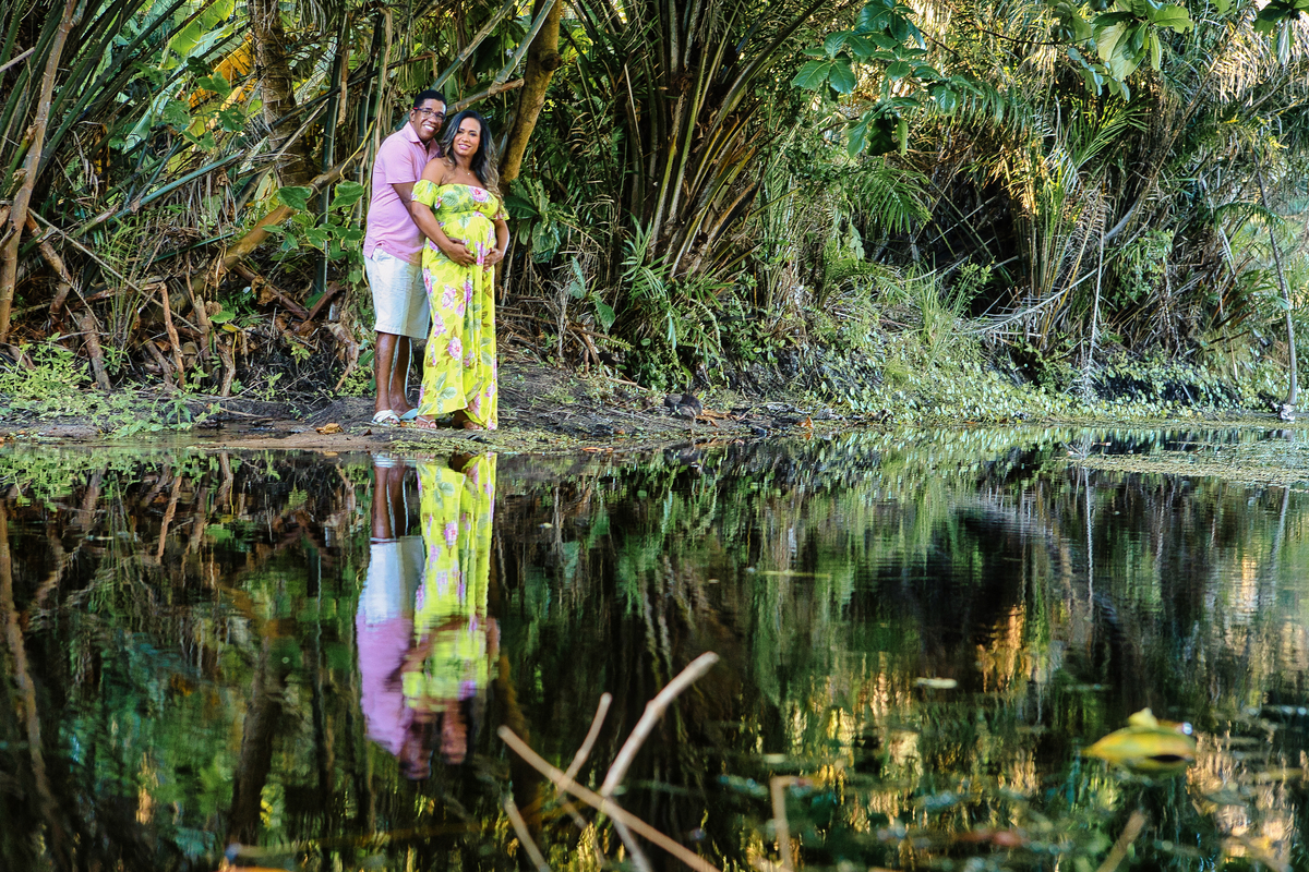 papai abraçando a barriga da gestante na beira do rio