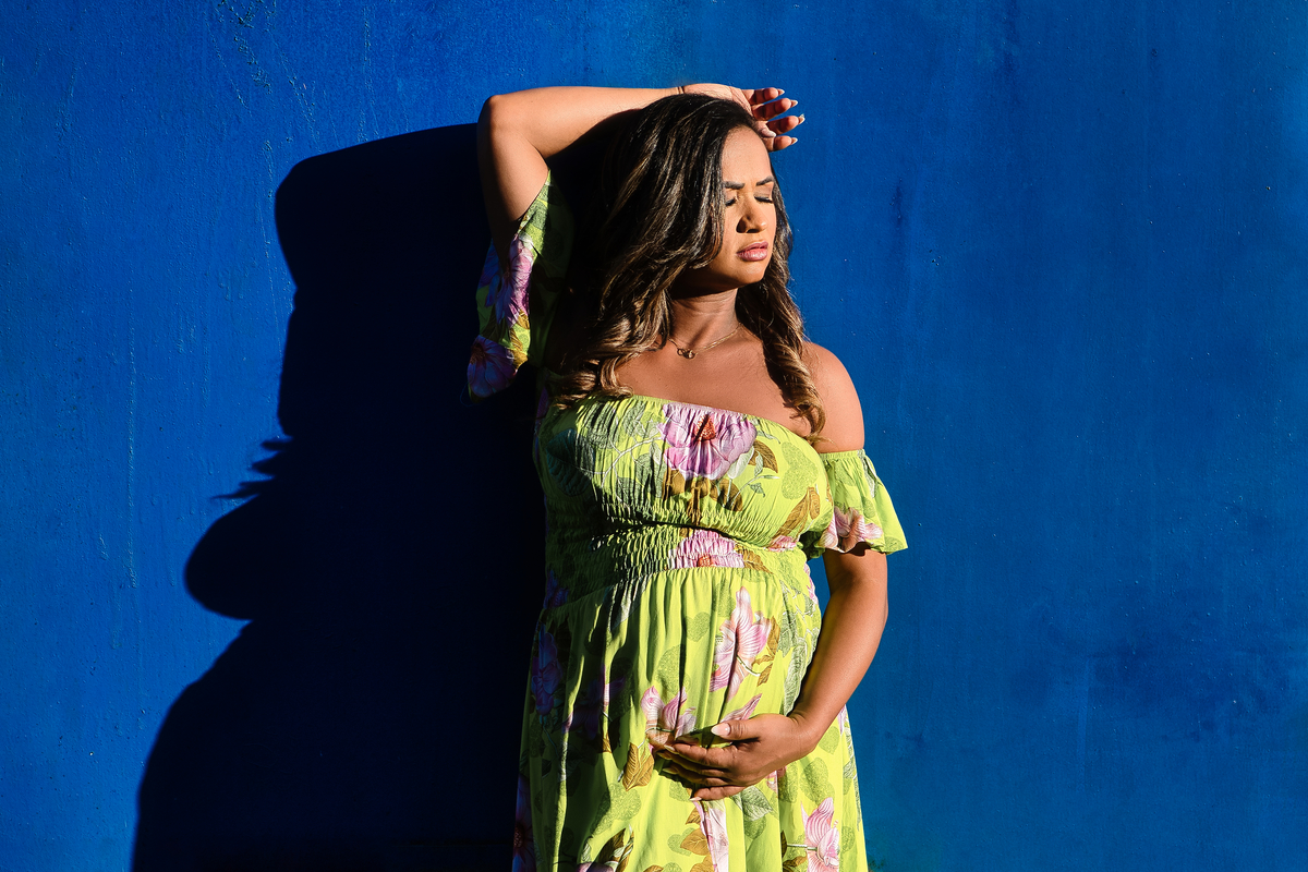 gestante encostada na parede, com mão na barriga e ou na cabeça