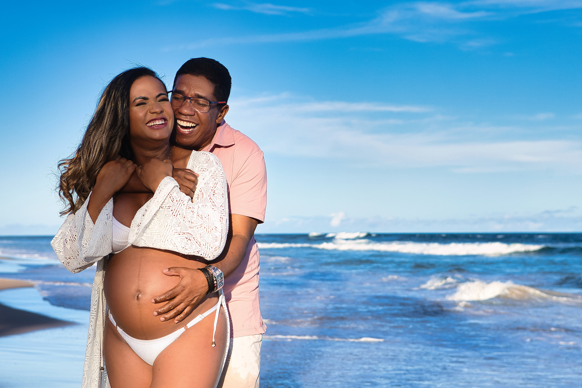 gestante e papai abraçados na beira do mar